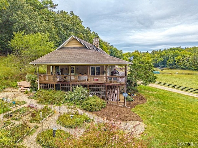 rear view of house featuring a lawn and a deck