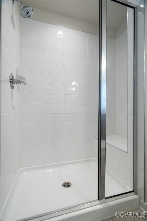 bathroom with tile patterned floors and a shower with door