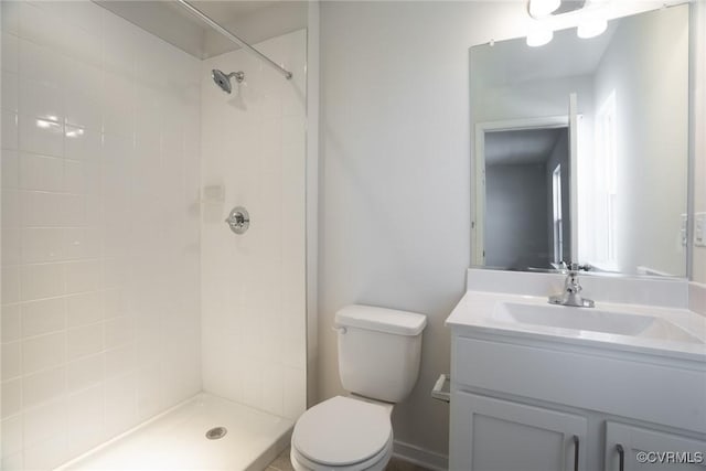 bathroom featuring vanity, toilet, and a tile shower