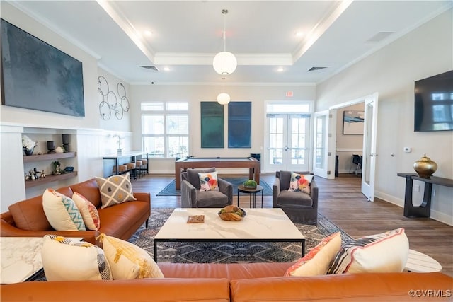 living room with french doors, dark hardwood / wood-style flooring, and a tray ceiling