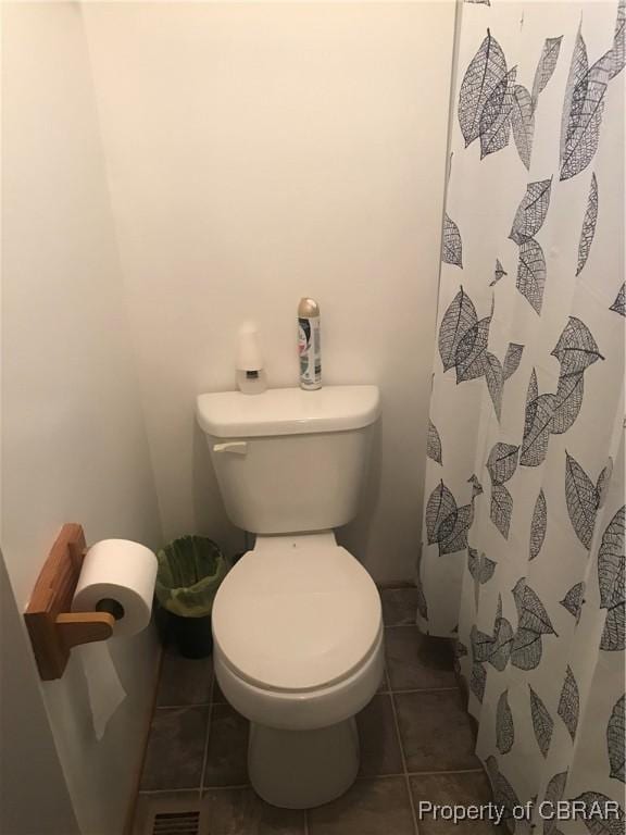 bathroom featuring tile patterned floors, toilet, and a shower with shower curtain