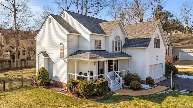 view of front of home featuring a porch, a garage, and a front yard