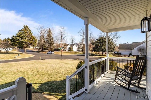 wooden deck with covered porch and a lawn