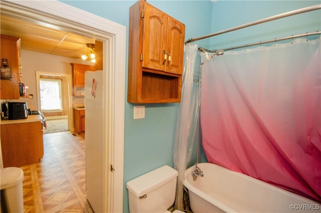 bathroom featuring shower / bath combo, parquet floors, and toilet