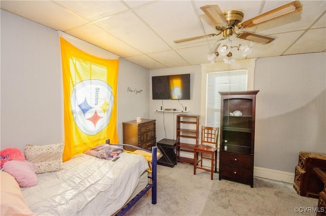 carpeted bedroom with a drop ceiling and ceiling fan