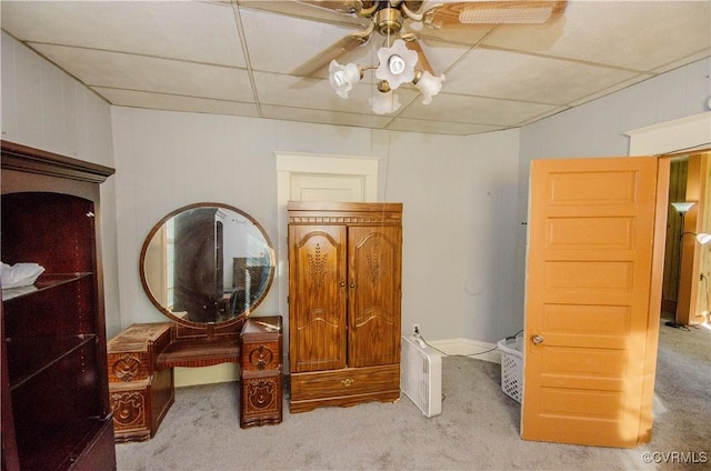 carpeted bedroom with a paneled ceiling and ceiling fan