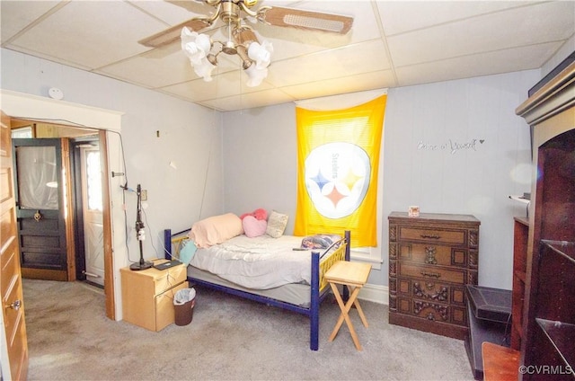 carpeted bedroom featuring a drop ceiling and ceiling fan