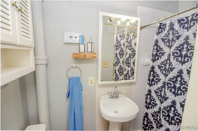 bathroom with walk in shower, sink, and decorative backsplash