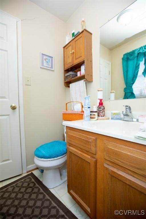 bathroom with tile patterned flooring, vanity, and toilet