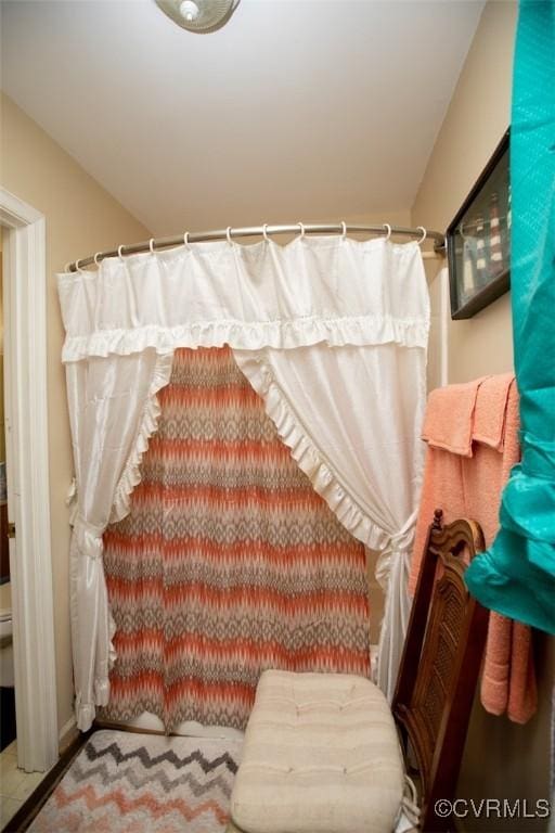 bathroom with a shower with curtain and toilet