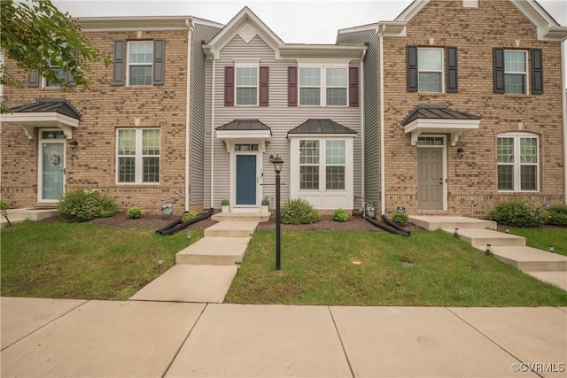 townhome / multi-family property with a front yard