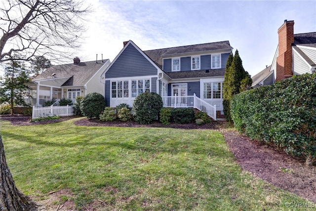 back of house featuring a lawn and fence