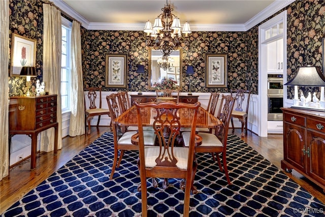 dining area featuring crown molding, an inviting chandelier, and wallpapered walls