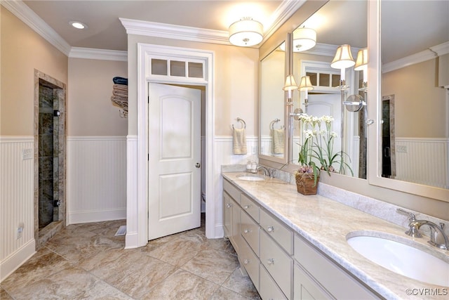 full bath with ornamental molding, wainscoting, and a sink