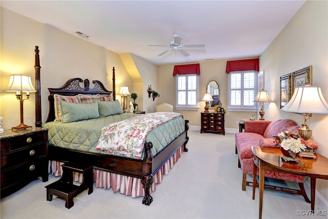 bedroom with a ceiling fan, light colored carpet, visible vents, and baseboards