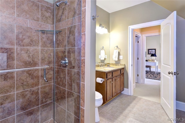 full bathroom with toilet, tiled shower, and vanity