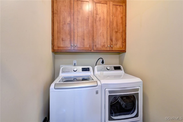 laundry area featuring washing machine and clothes dryer and cabinet space