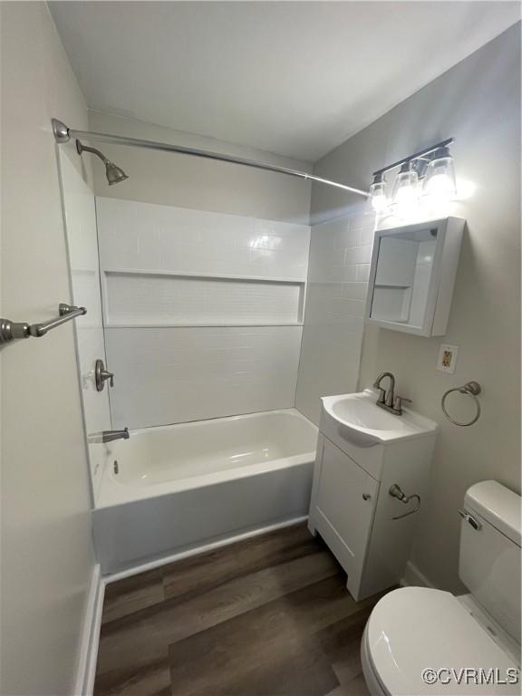 full bathroom with hardwood / wood-style flooring, shower / bathtub combination, vanity, and toilet