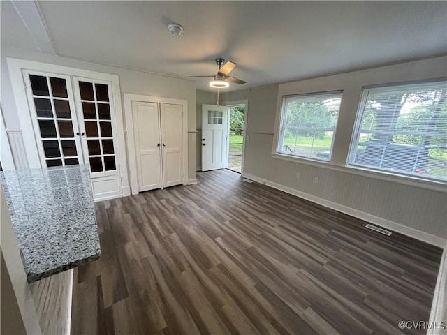 unfurnished dining area featuring french doors, ceiling fan, and dark hardwood / wood-style floors