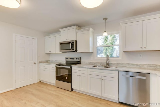 kitchen with stainless steel appliances, hanging light fixtures, sink, and white cabinets