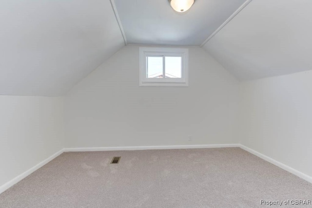 bonus room featuring lofted ceiling and carpet flooring