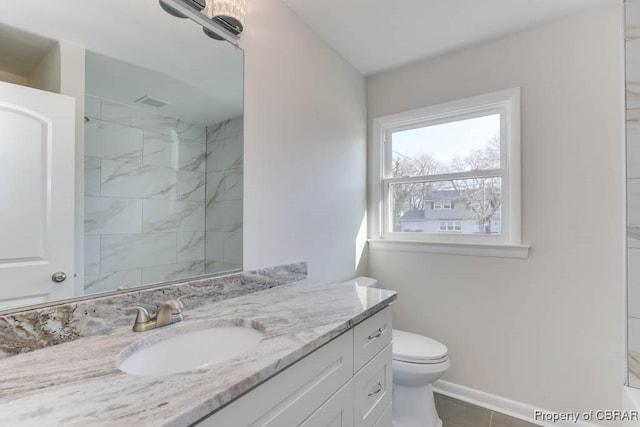 bathroom with tile patterned floors, vanity, toilet, and a tile shower