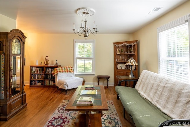 sitting room featuring plenty of natural light, hardwood / wood-style floors, and a notable chandelier