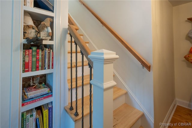 stairs with built in shelves and wood-type flooring