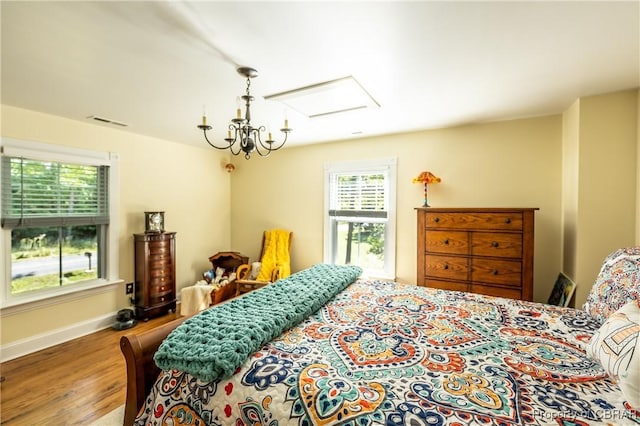 bedroom with hardwood / wood-style floors and a notable chandelier