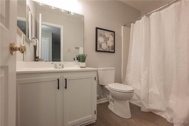 full bathroom featuring vanity, hardwood / wood-style floors, shower / tub combo, and toilet