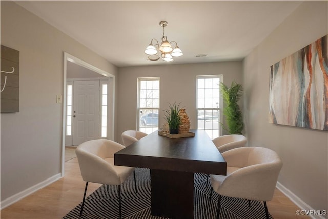 dining room with an inviting chandelier and light wood-type flooring