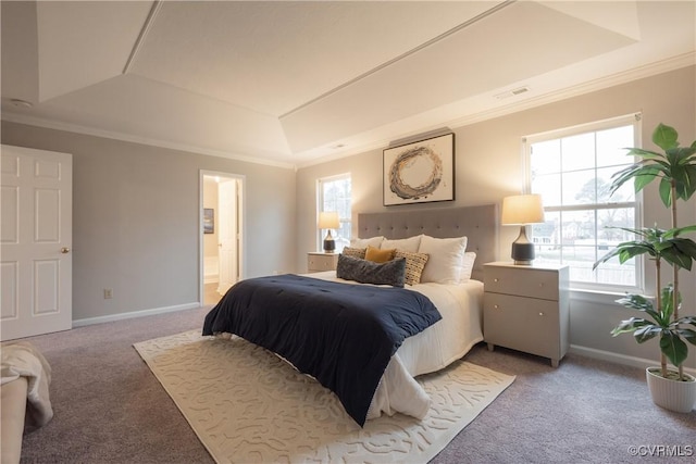 bedroom featuring ensuite bath, carpet floors, ornamental molding, and a raised ceiling