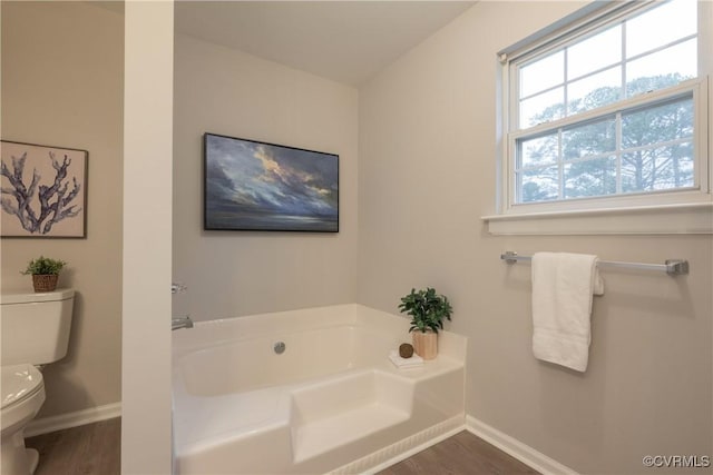 bathroom featuring a bathtub, toilet, and hardwood / wood-style flooring