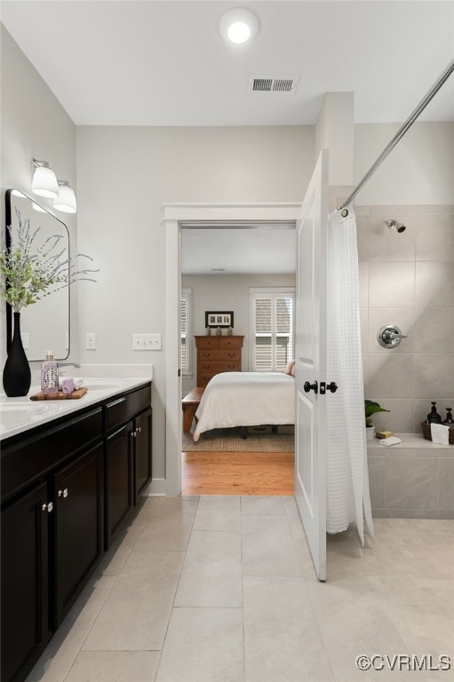 bathroom featuring vanity, tile patterned floors, and walk in shower