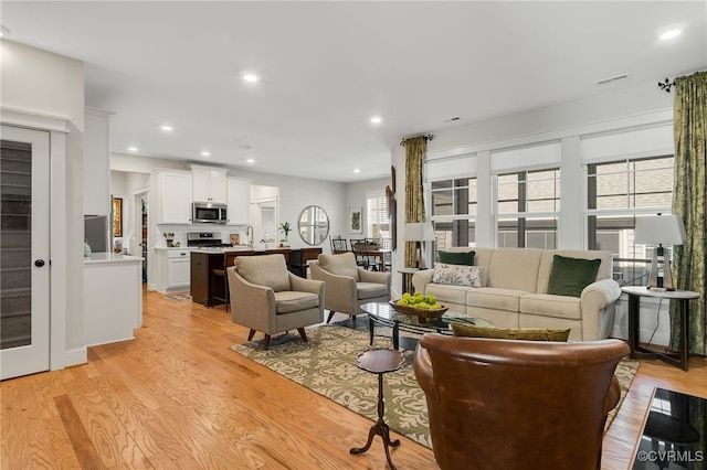 living room with sink and light wood-type flooring