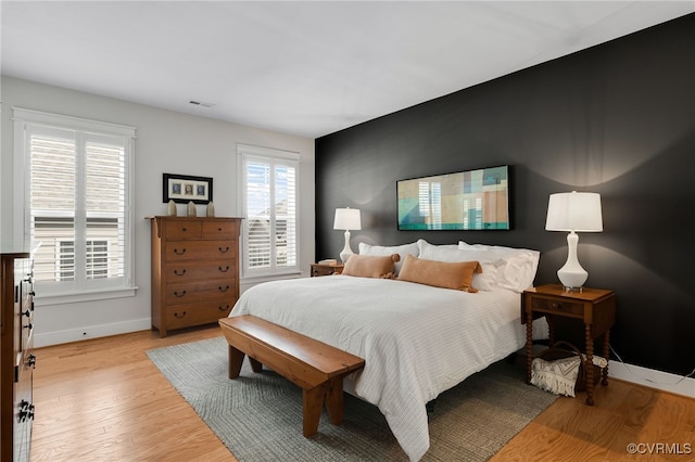 bedroom with multiple windows and light wood-type flooring