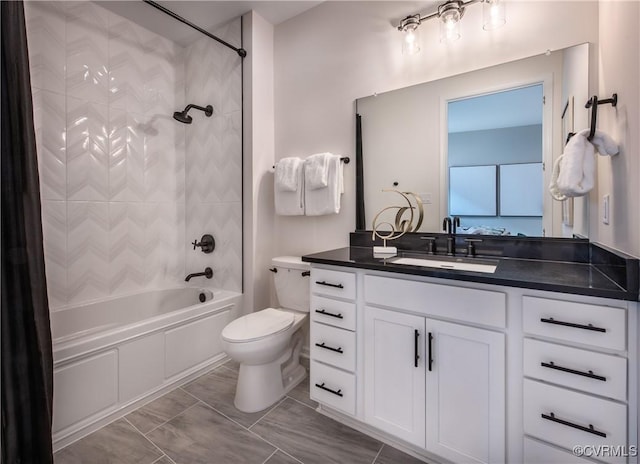 full bathroom featuring vanity, tiled shower / bath combo, and toilet