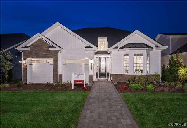 view of front of property with a garage and a lawn