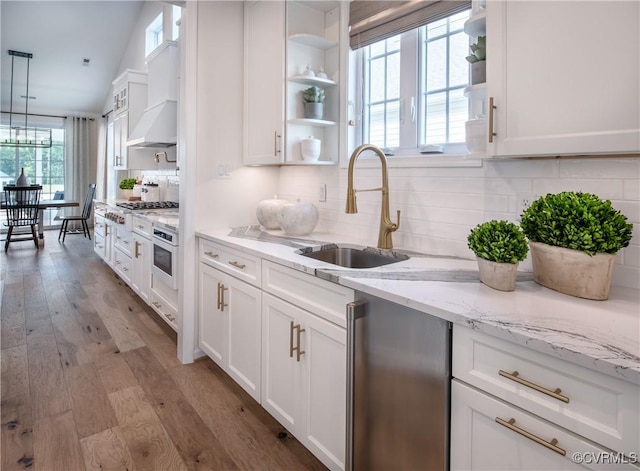 kitchen featuring oven, sink, and white cabinets