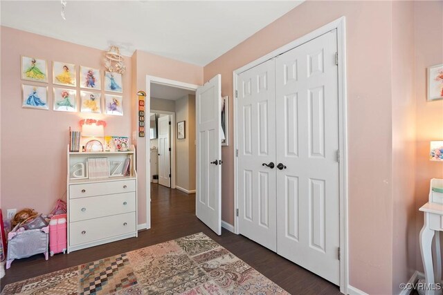 bedroom with dark hardwood / wood-style floors and a closet