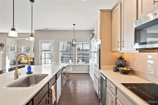 kitchen featuring sink, appliances with stainless steel finishes, backsplash, dark hardwood / wood-style flooring, and decorative light fixtures