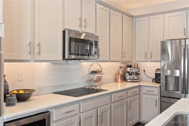 kitchen with appliances with stainless steel finishes, beverage cooler, decorative backsplash, and gray cabinetry