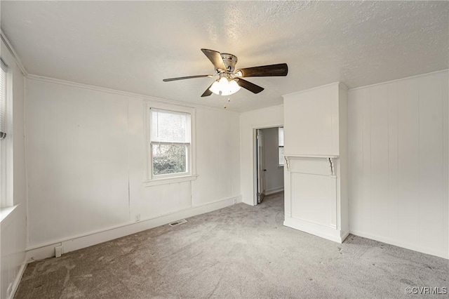 carpeted spare room featuring ceiling fan and a textured ceiling