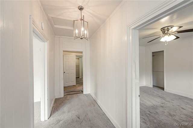 hallway featuring light carpet and a notable chandelier