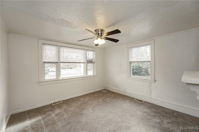 carpeted empty room featuring ceiling fan and a textured ceiling