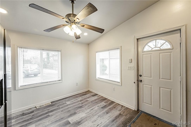 foyer featuring vaulted ceiling, ceiling fan, and light wood-type flooring