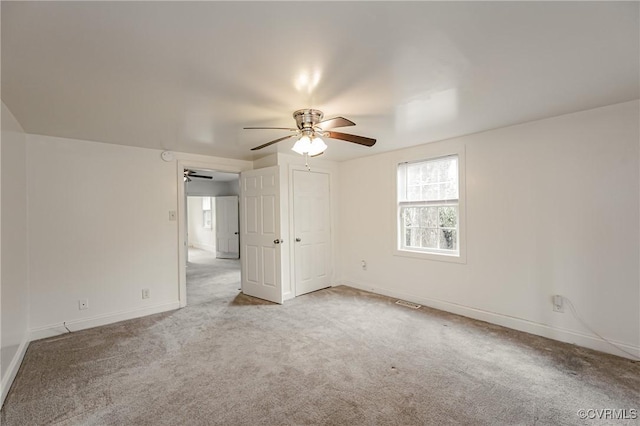 spare room with light colored carpet and ceiling fan