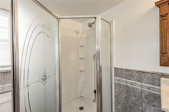 bathroom featuring tile walls, an enclosed shower, and toilet