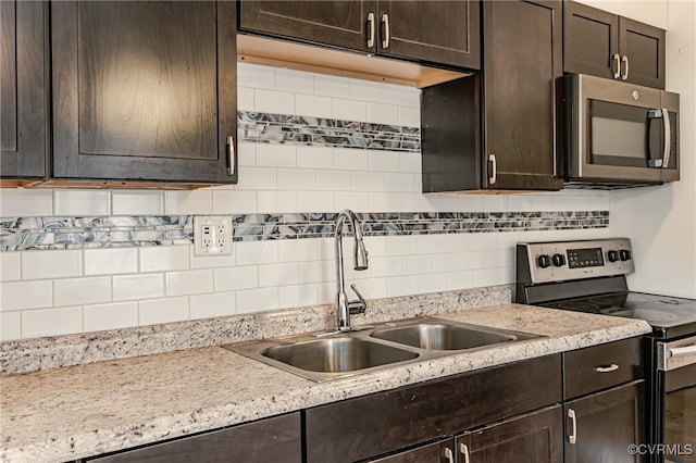 kitchen with tasteful backsplash, dark brown cabinetry, stainless steel appliances, and sink