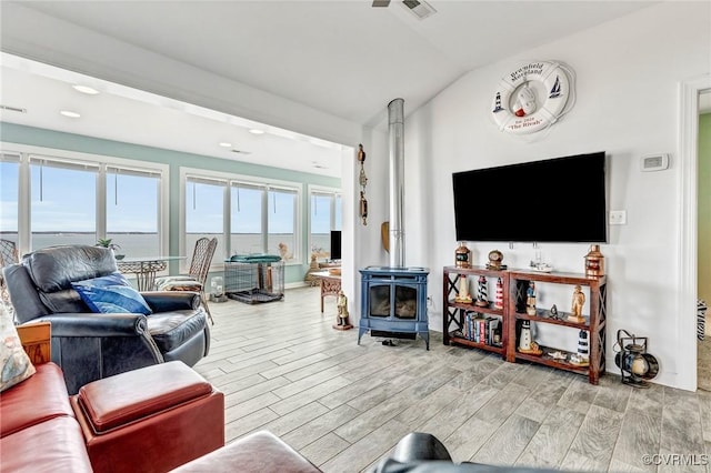 living room featuring lofted ceiling and a wood stove